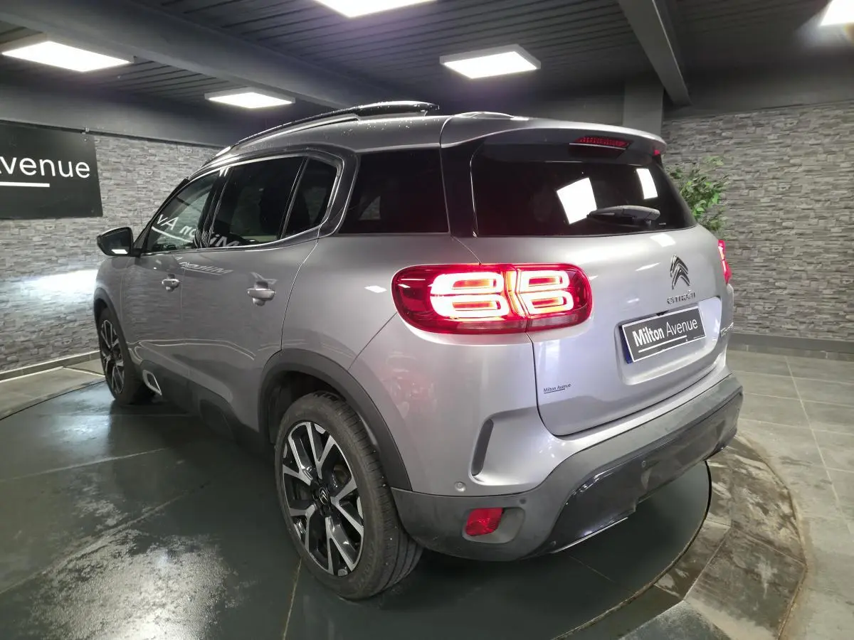 Vue 3/4 arrière droite d'un Citroën C5 Aircross gris métallisé avec feux arrière LED et jantes alliage 19 pouces.