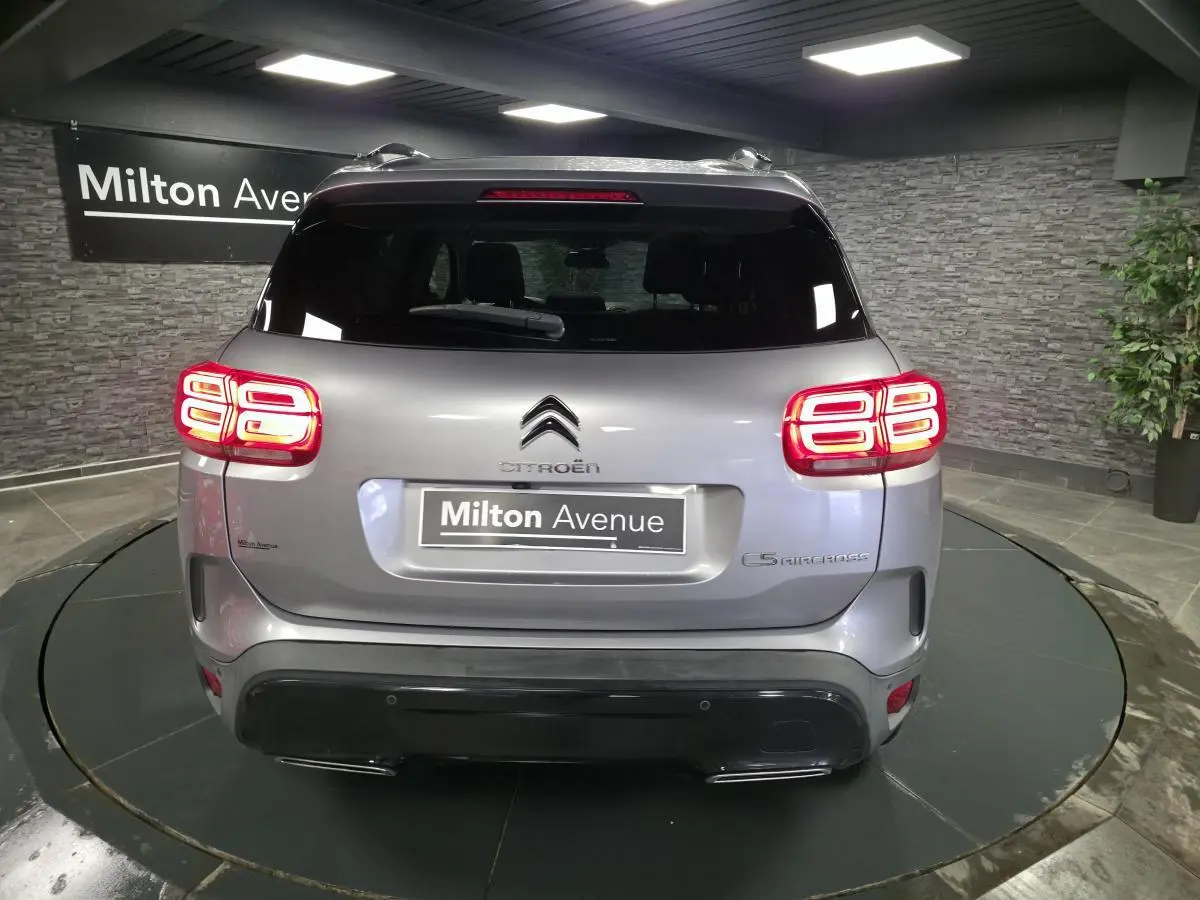 Vue arrière d'un Citroën C5 Aircross gris métallisé avec feux arrière LED et double sortie d'échappement.