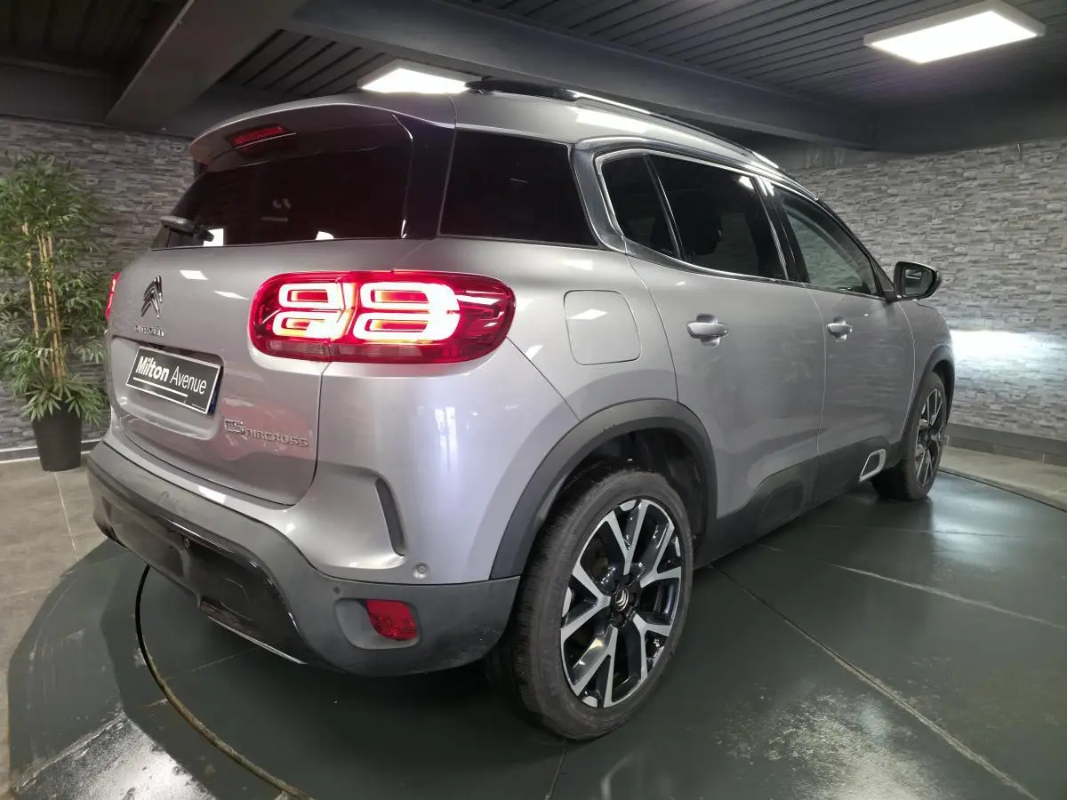 Vue 3/4 arrière droite d'un Citroën C5 Aircross gris métallisé avec feux arrière LED distinctifs et jantes alliage 19 pouces.