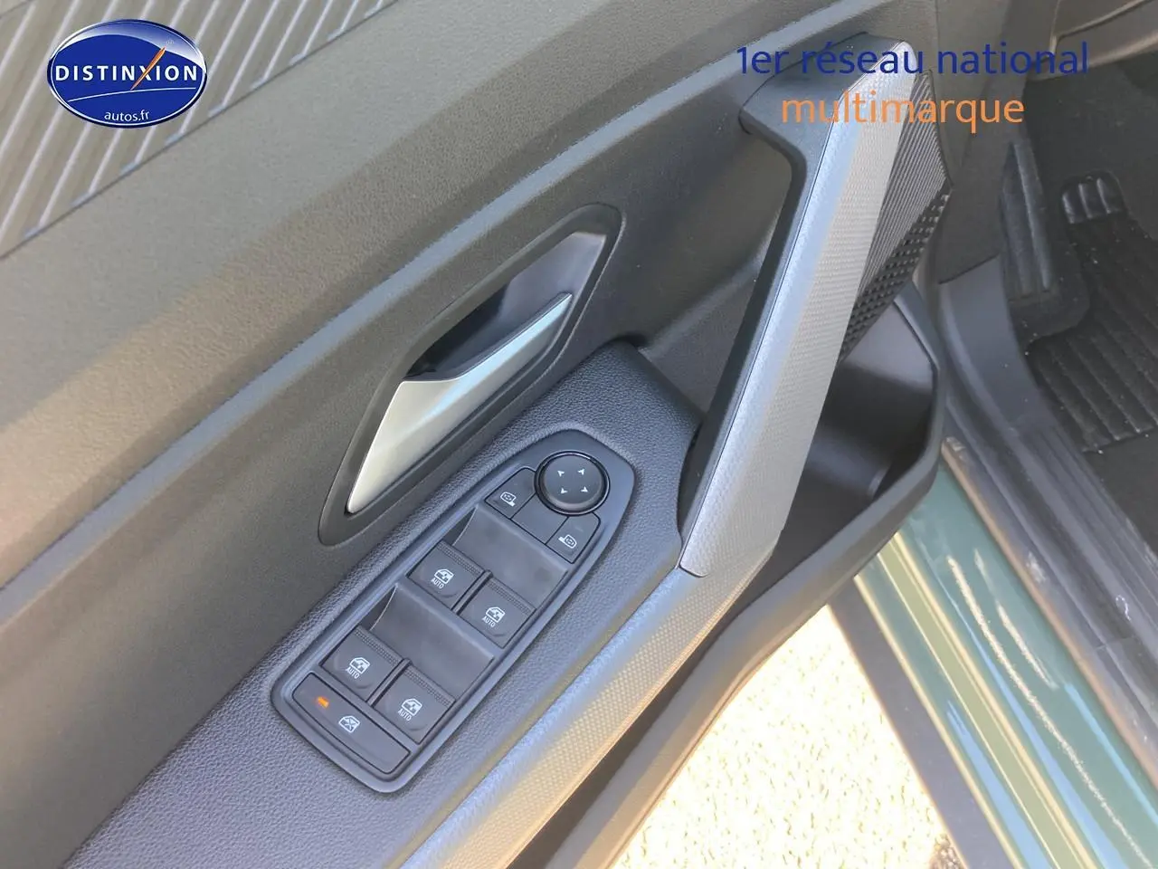 Détail de la porte avant gauche du Dacia Duster 2026 kaki lichen avec commandes électriques des vitres et rétroviseurs.