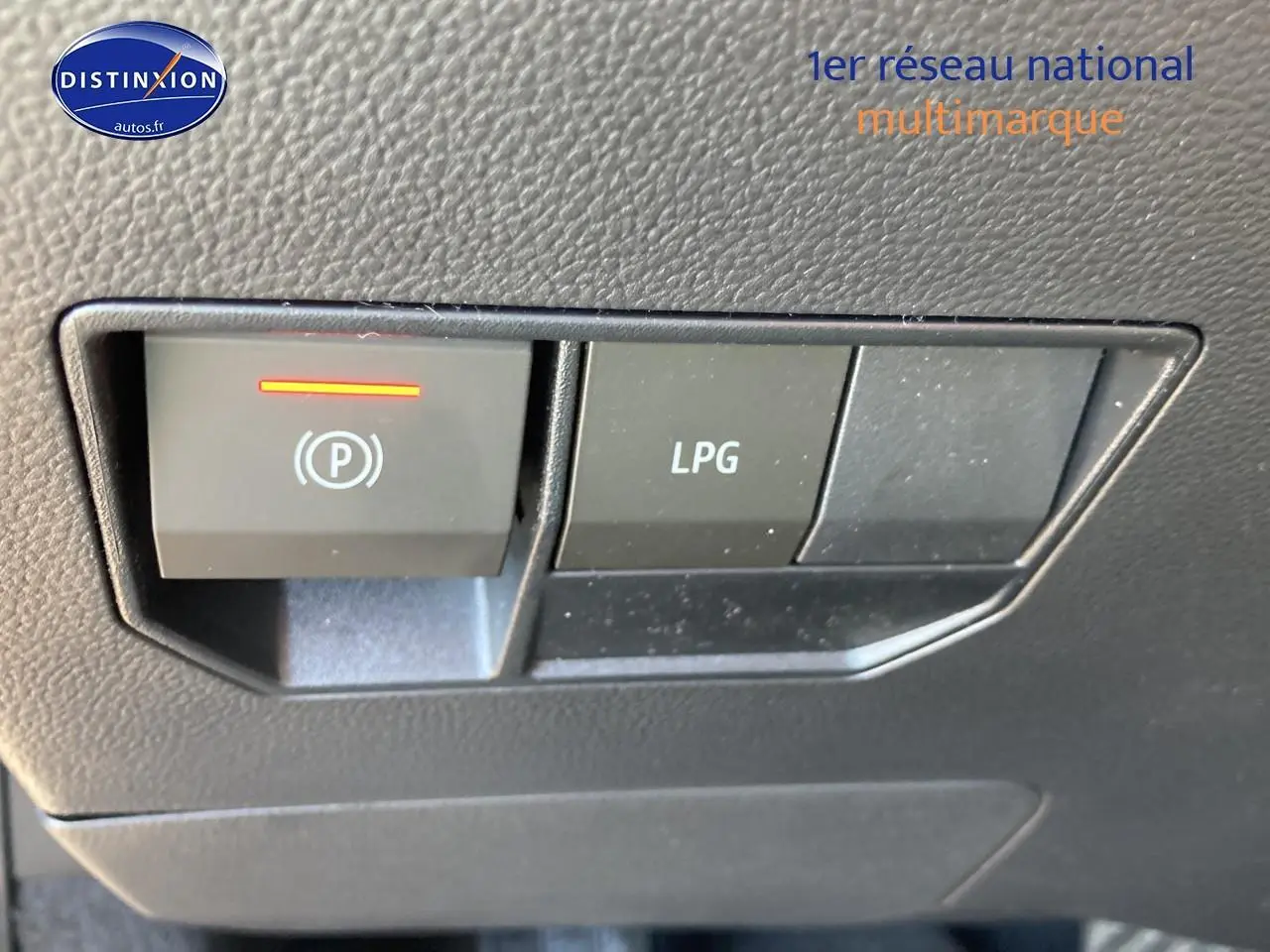 Gros plan sur les boutons de commande LPG et frein à main électrique dans un Dacia Duster 2026.
