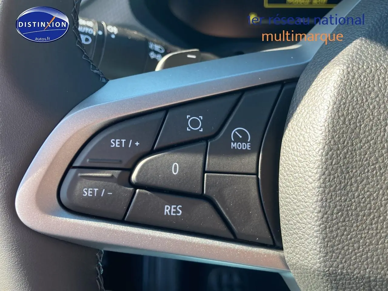 Gros plan sur les commandes multifonctions noires du volant du Dacia Duster 2026, finition expression.