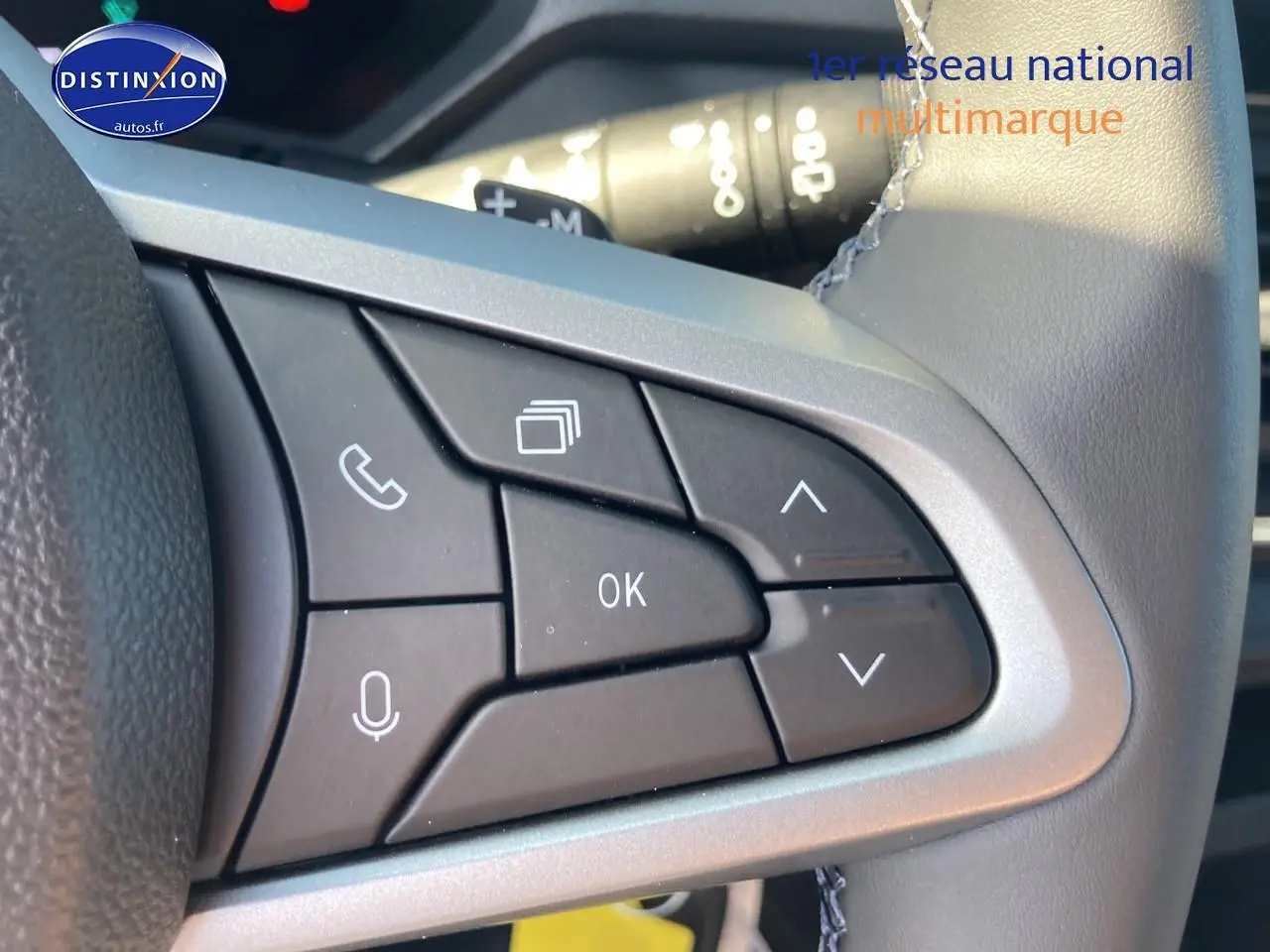Gros plan sur les commandes multifonctions à droite du volant du Dacia Duster 2026, finition kaki lichen.