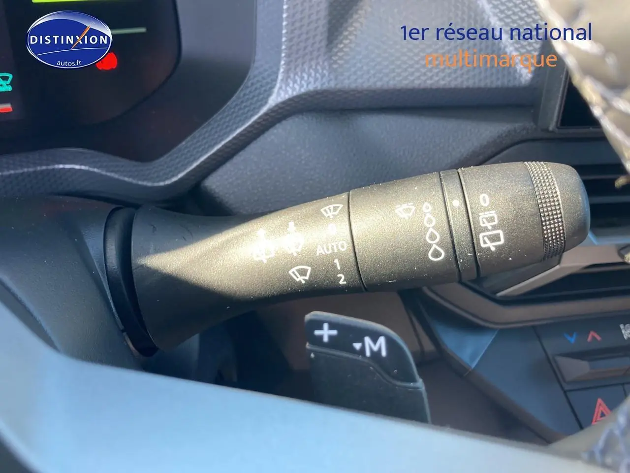Gros plan sur la commande d’essuie-glace à gauche du volant du Dacia Duster 2026, intérieur noir et gris.