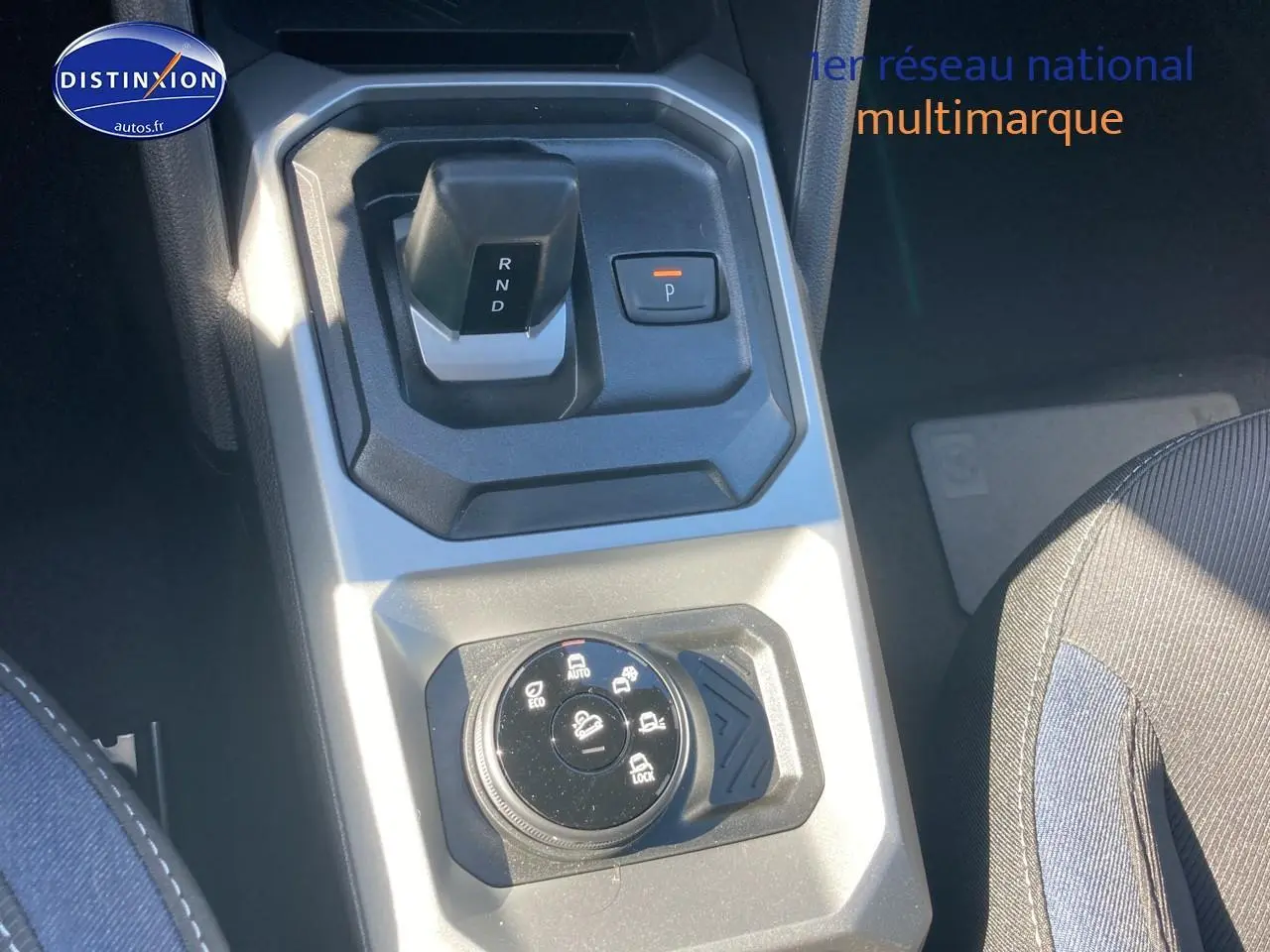 Vue plongeante sur la console centrale du Dacia Duster 2026, avec sélecteur de boîte auto et commande modes de conduite.