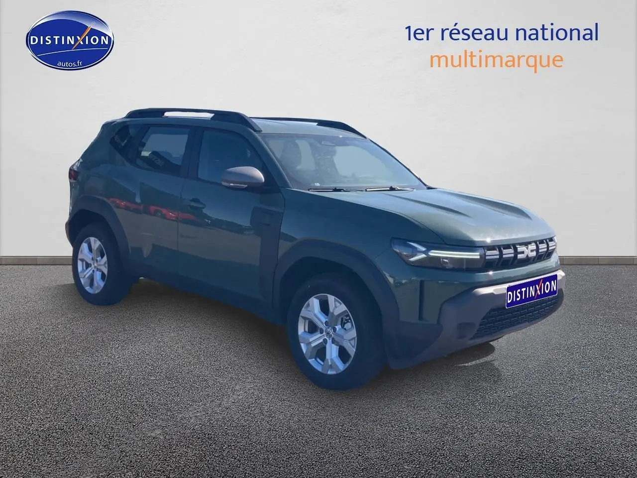 Vue 3/4 avant d'un Dacia Duster 2026 kaki lichen avec barres de toit et jantes alu visibles.