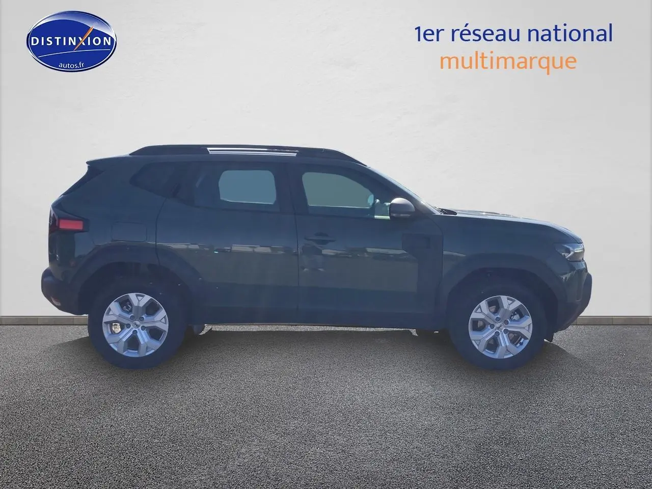 Profil droit du Dacia Duster 1.2 hybrid-g 150 expression 4x4 en kaki lichen avec jantes alu et barres de toit.