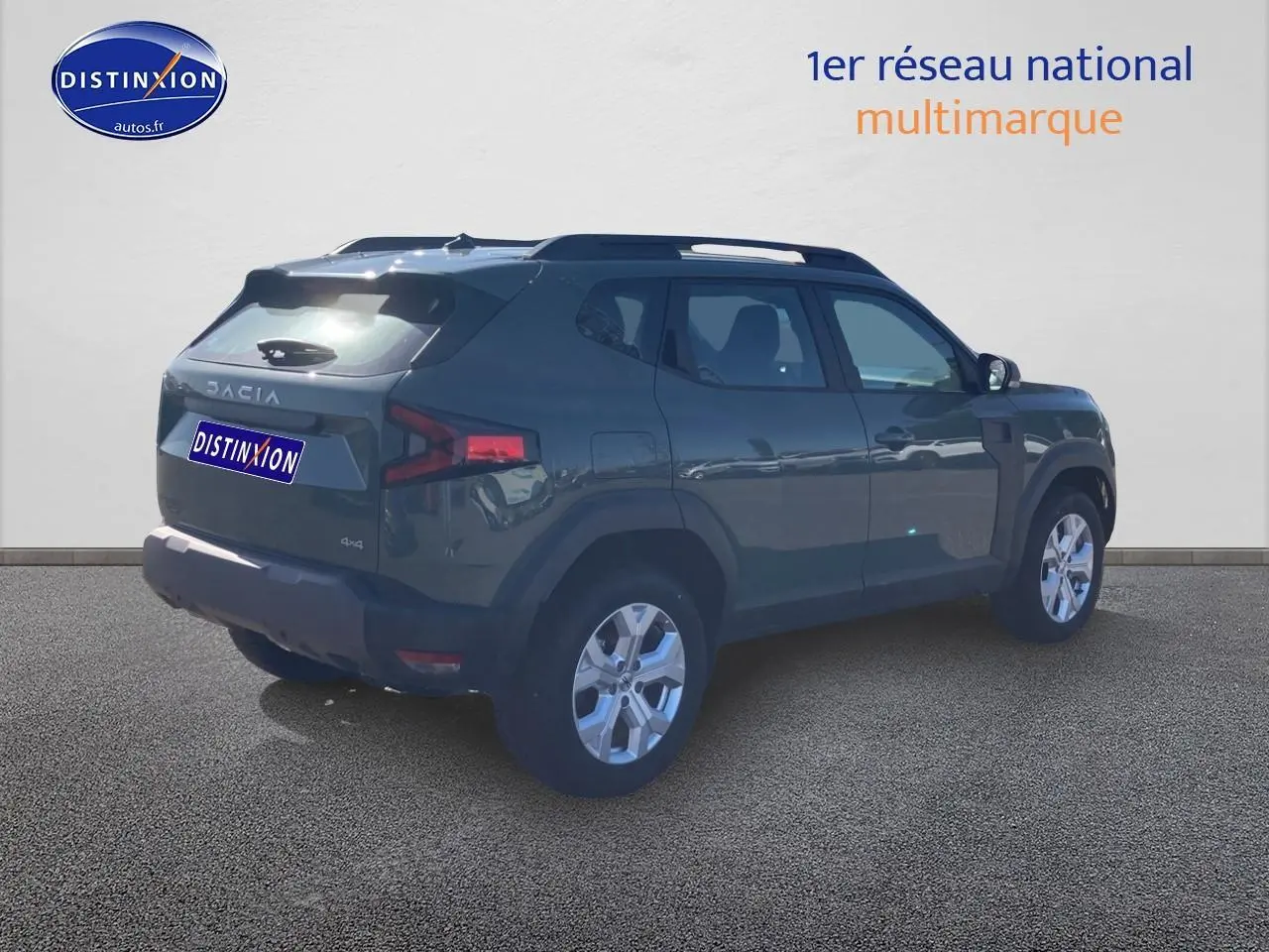 Vue 3/4 arrière droite d'un Dacia Duster 2026 kaki lichen avec barres de toit et jantes alu.
