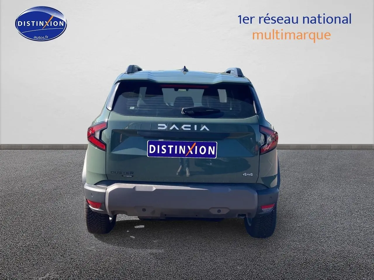 Vue arrière d'un Dacia Duster 1.2 hybrid-g 150 expression 4x4 en kaki lichen avec barres de toit et becquet.