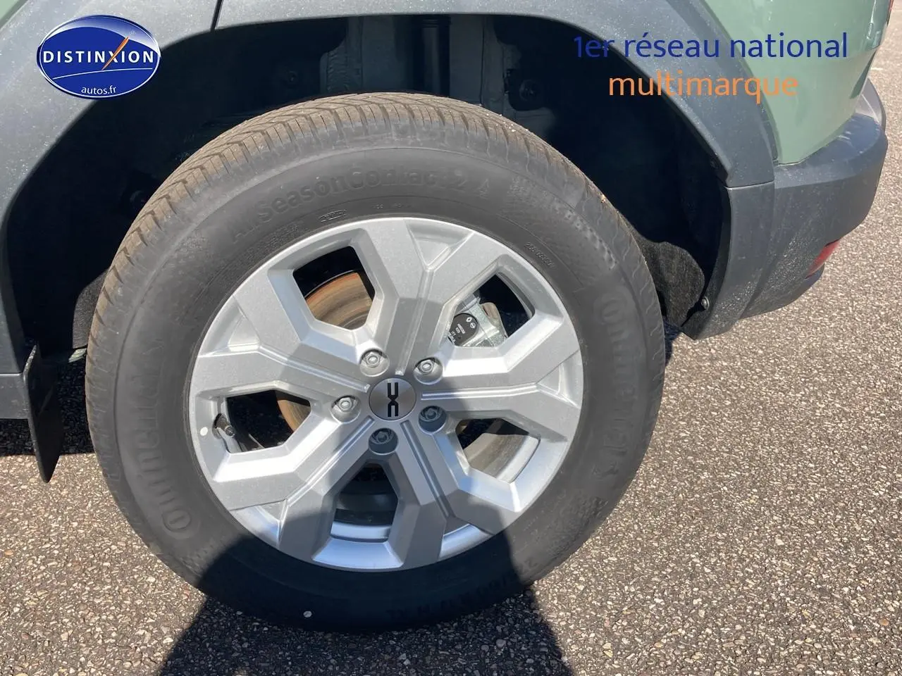 Gros plan sur la roue avant gauche avec jante alu du Dacia Duster 1.2 hybrid-g 150 kaki lichen 2026.