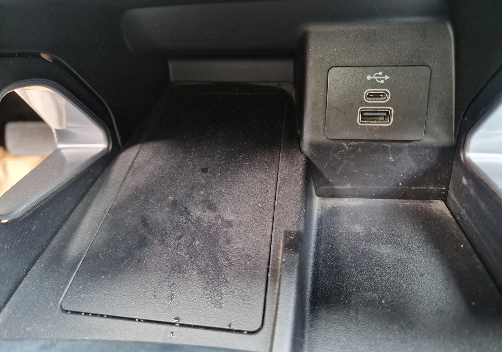 Gros plan sur la console centrale du Ford Ranger Wildtrak 2023, montrant les ports USB et un espace de rangement noir.