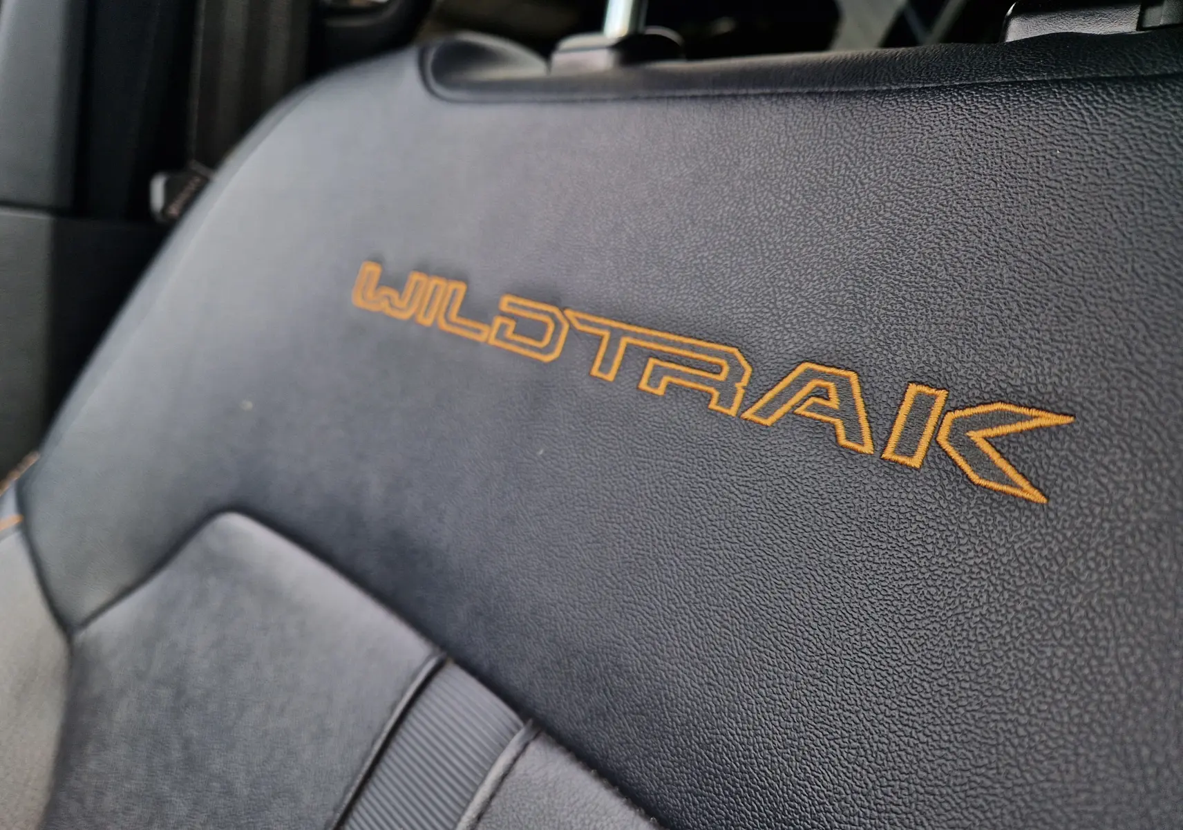 Gros plan sur le siège en cuir noir avec broderie orange "WILDTRAK" du Ford Ranger Double Cabine 2023.