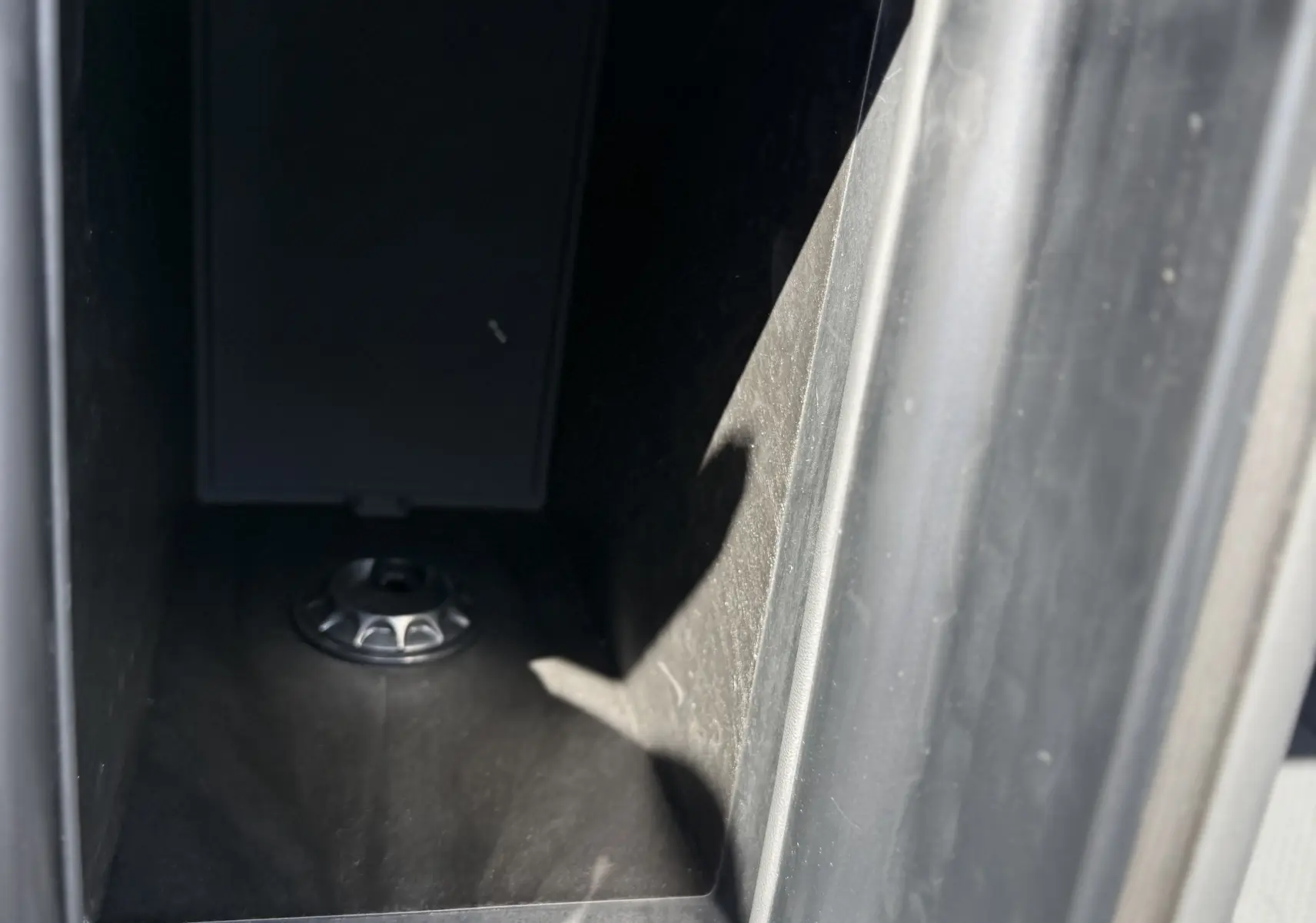 Vue rapprochée de la console centrale ouverte du JAECOO J7 noir crystal, montrant un espace de rangement intérieur.