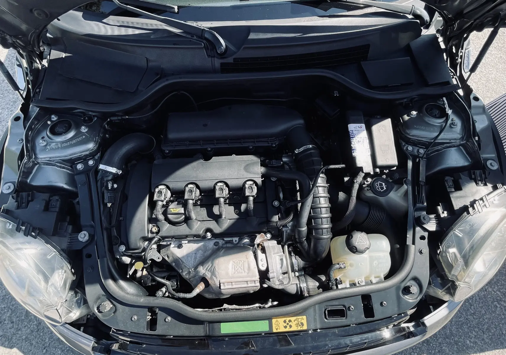 Moteur de la MINI Cooper S gris 2008 vu de dessus, capot ouvert, montrant les composants du compartiment moteur.