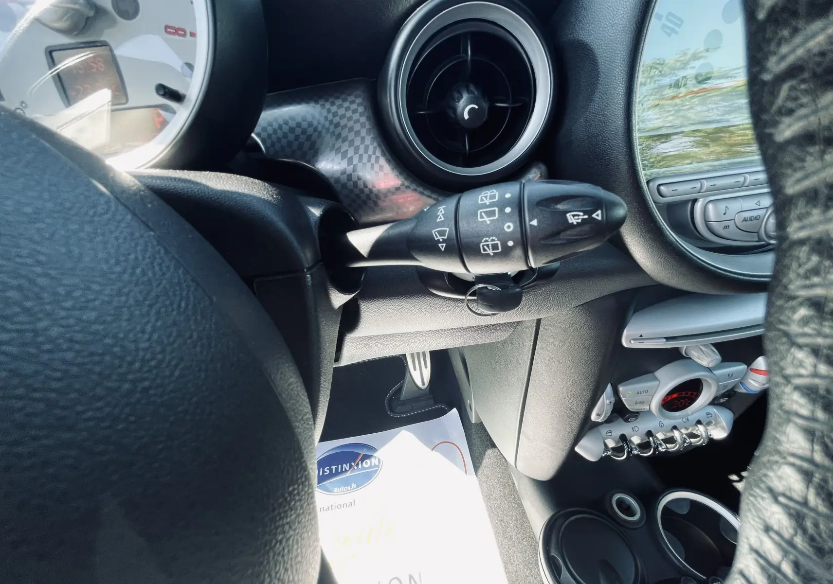 Intérieur MINI Cooper S 2008 vu côté gauche, volant, commandes d’essuie-glace et tableau de bord avec climatisation digitale.