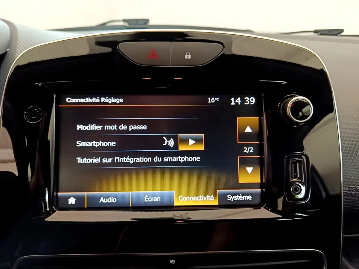 Gros plan sur l'écran tactile central noir de la Renault Clio Business TCe 90 blanc, affichant les réglages de connectivité smartphone.