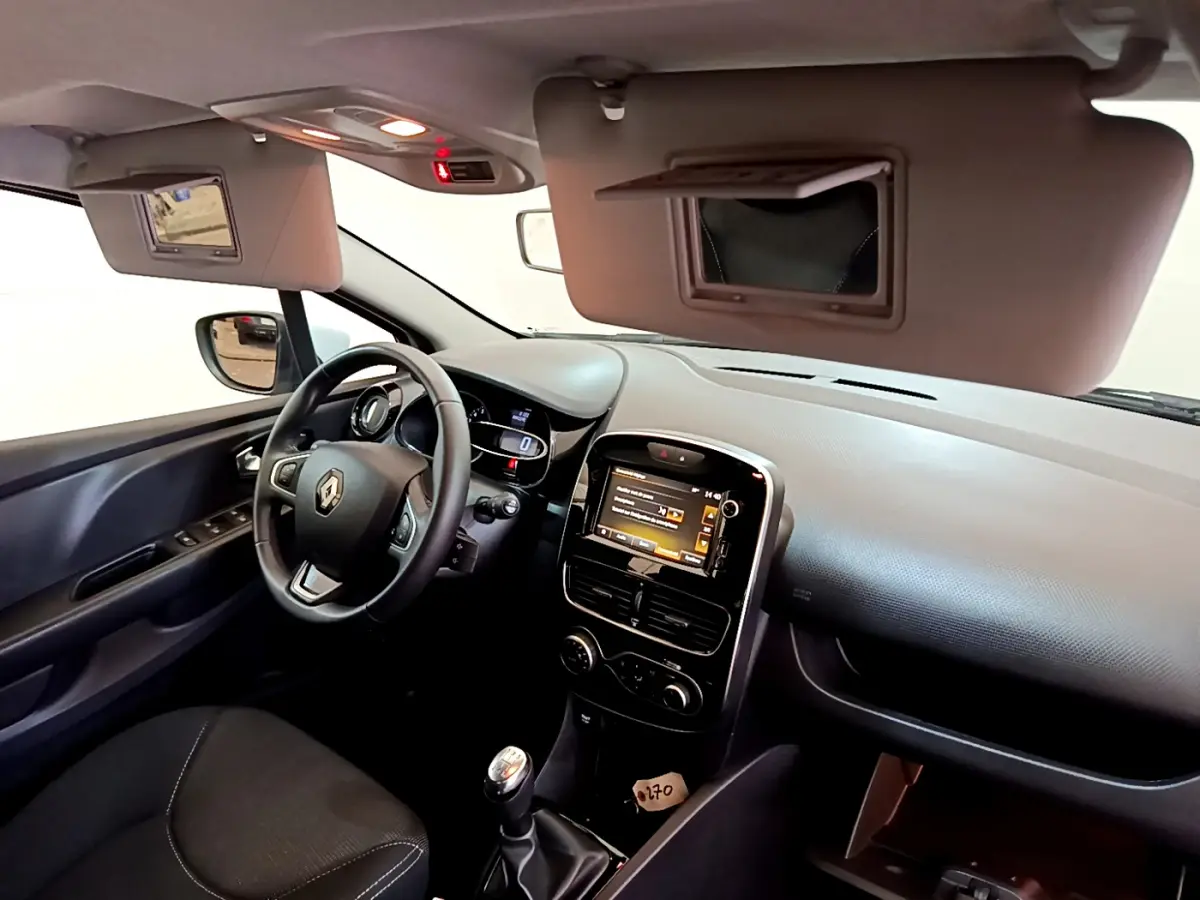 Intérieur de Renault Clio Business TCe 90 2019, vue côté conducteur, volant cuir et écran tactile central allumé.