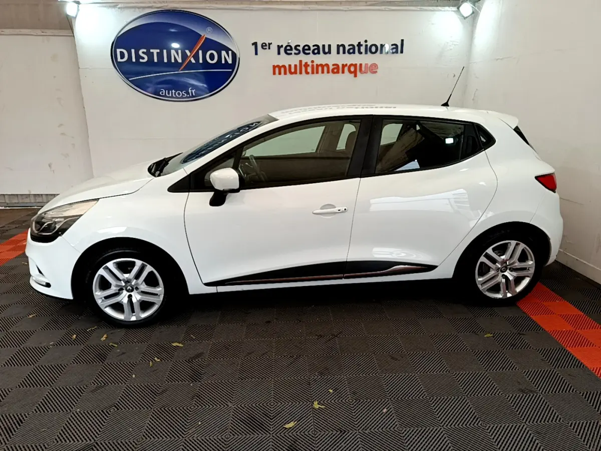 Profil côté gauche d'une Renault Clio Business TCe 90 blanche, avec jantes alliage et rétroviseurs assortis.