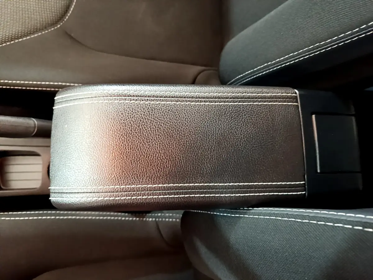 Gros plan sur l'accoudoir central en cuir noir avec surpiqûres blanches de la Renault Clio Business TCe 90 2019.