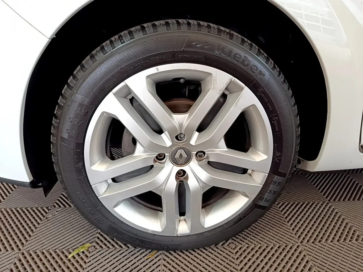 Gros plan sur la roue avant droite blanche d'une Renault Clio Business TCe 90 de 2019 avec jante alliage argentée.