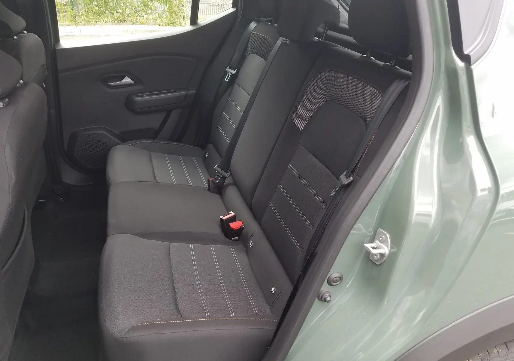 Vue côté gauche de la banquette arrière noire de la Dacia Sandero Stepway 2025 en Licken Kaki métallisé.