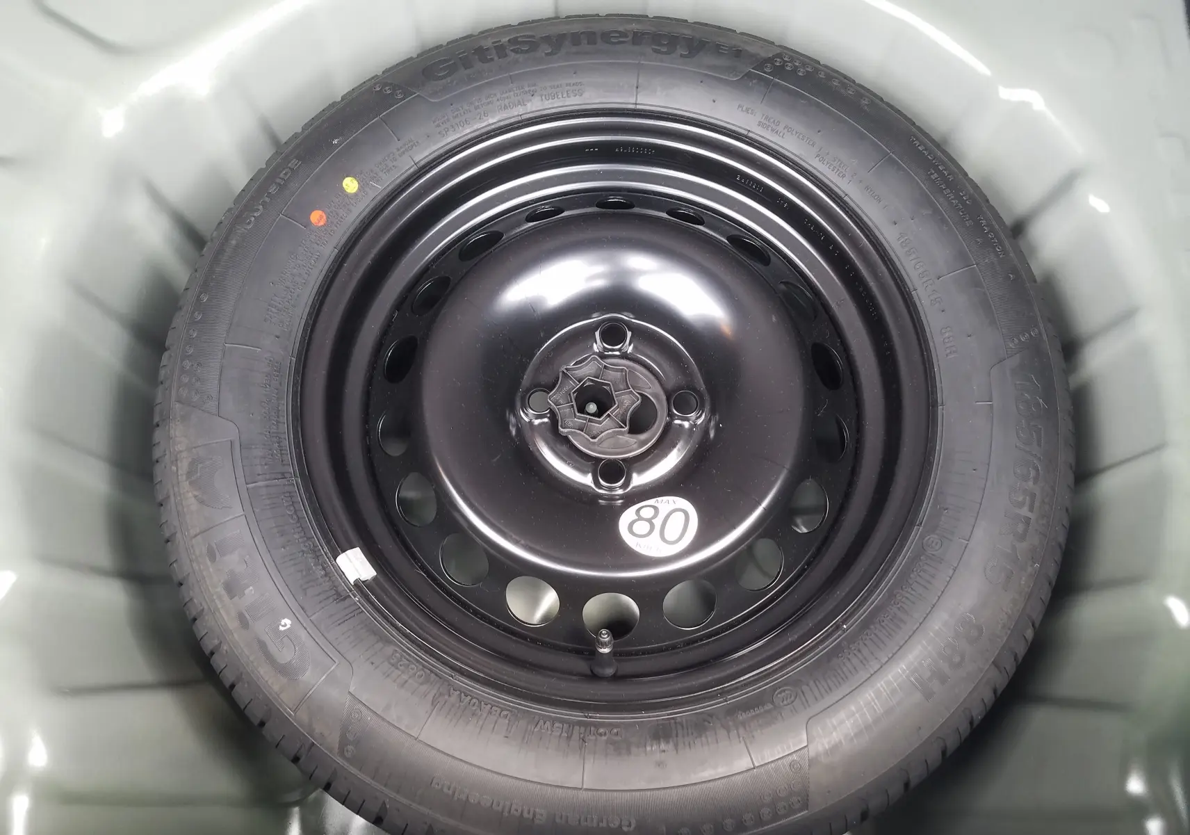 Roue de secours noire en gros plan dans le coffre d'une Dacia Sandero Stepway 2025 couleur Licken Kaki.