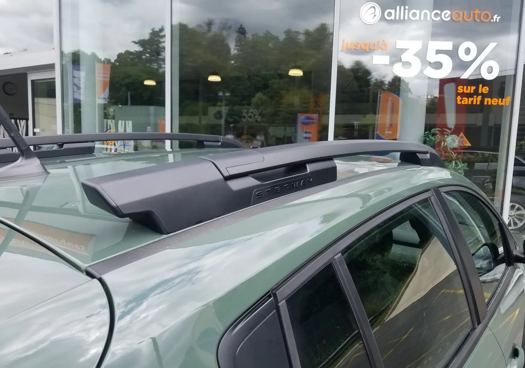 Gros plan sur les barres de toit longitudinales noires du Dacia Sandero Stepway 2025 en Licken Kaki, côté gauche.