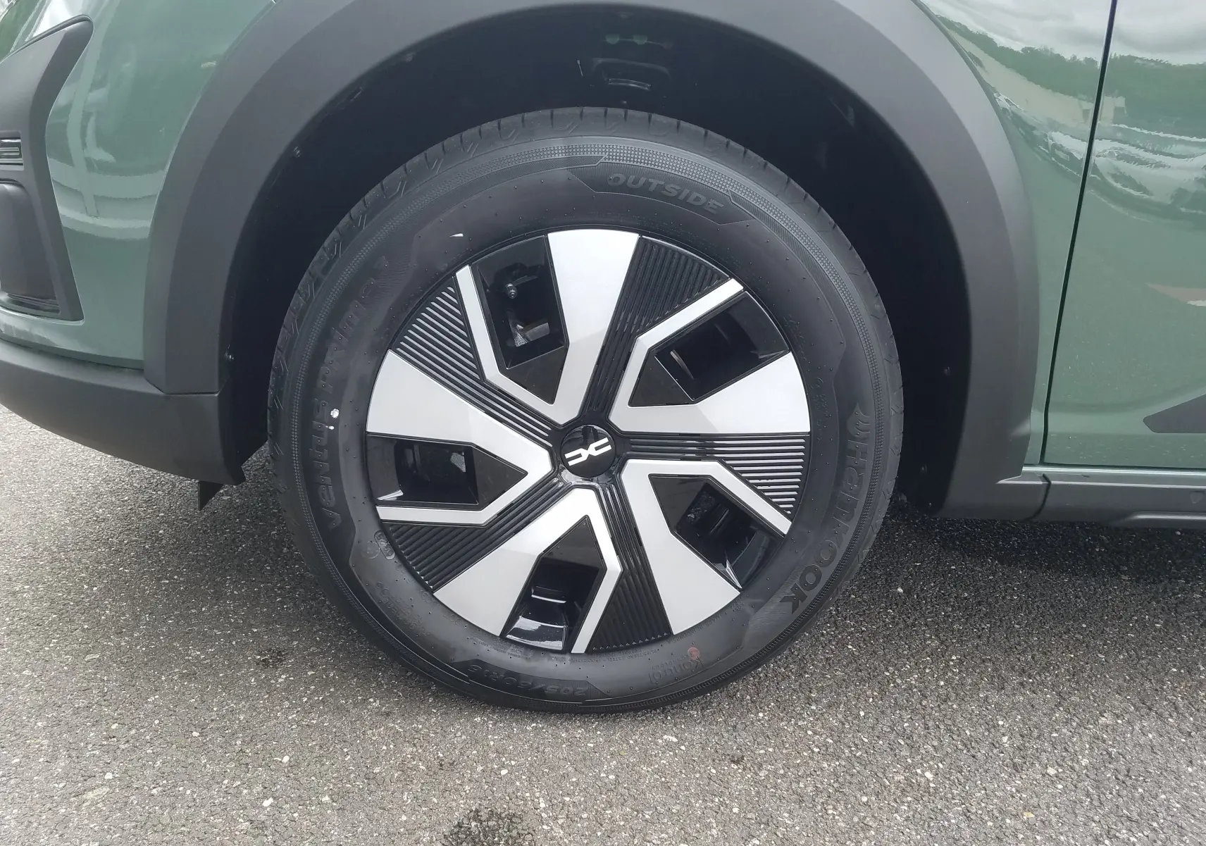 Gros plan sur la roue avant gauche de la Dacia Sandero Stepway 2025 en Licken Kaki avec jante au design moderne noir et argent.