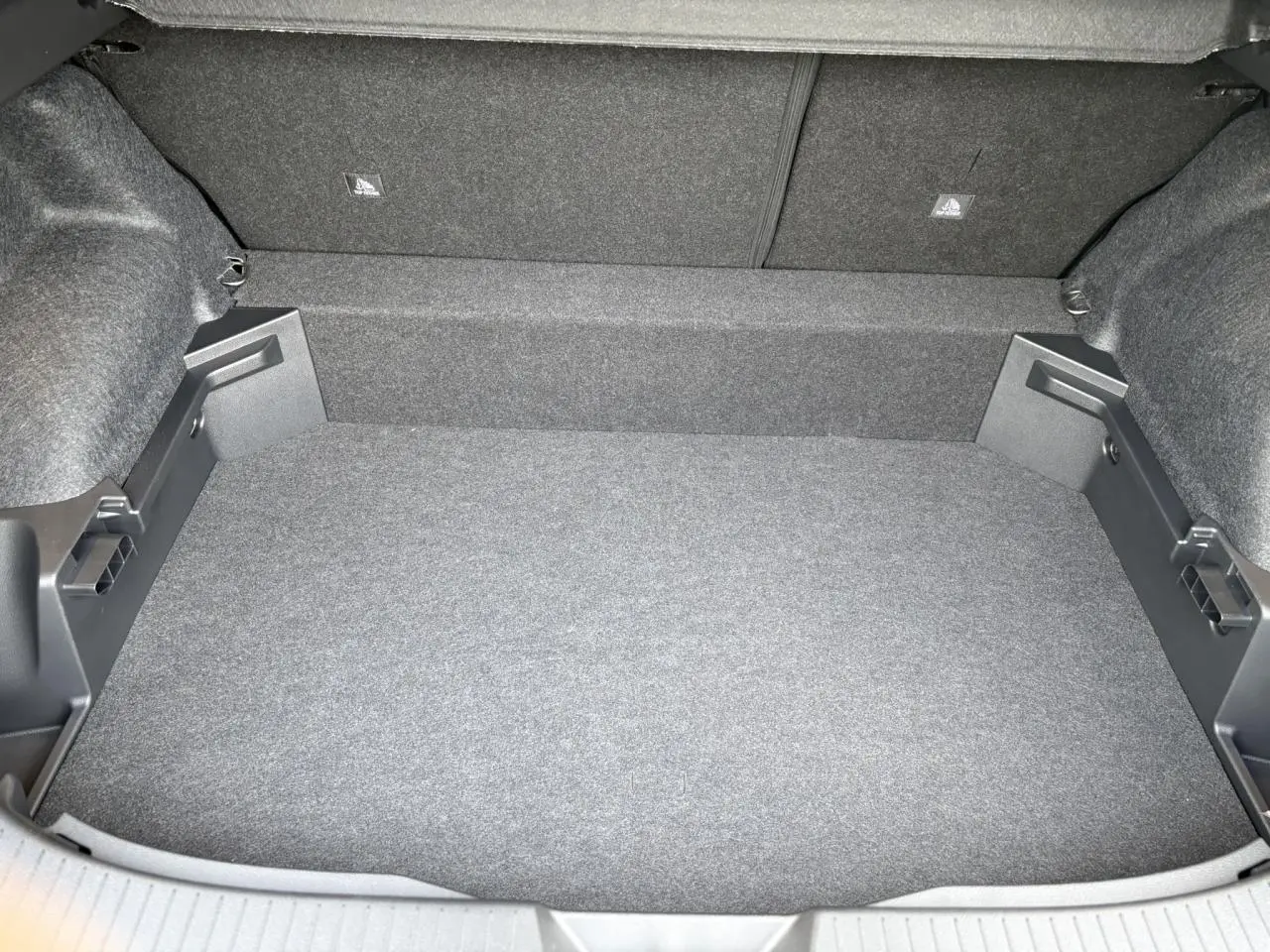 Coffre spacieux et vide du Nissan Qashqai III e-Power 2025, vue de dessus avec revêtement gris uniforme.