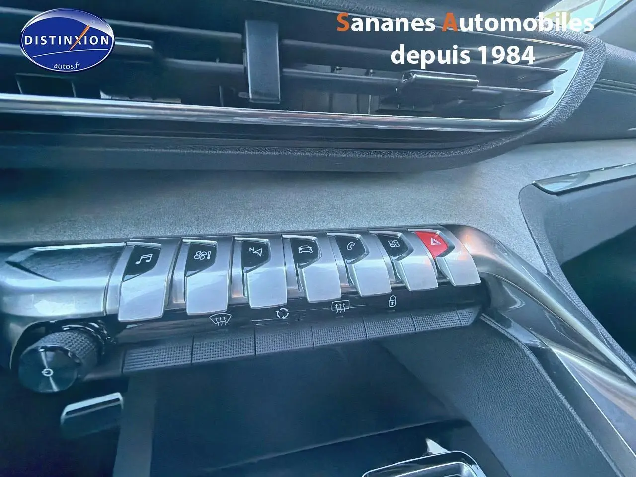 Gros plan sur la rangée de commandes chromées du tableau de bord intérieur du Peugeot 3008, finition GT, 2023.