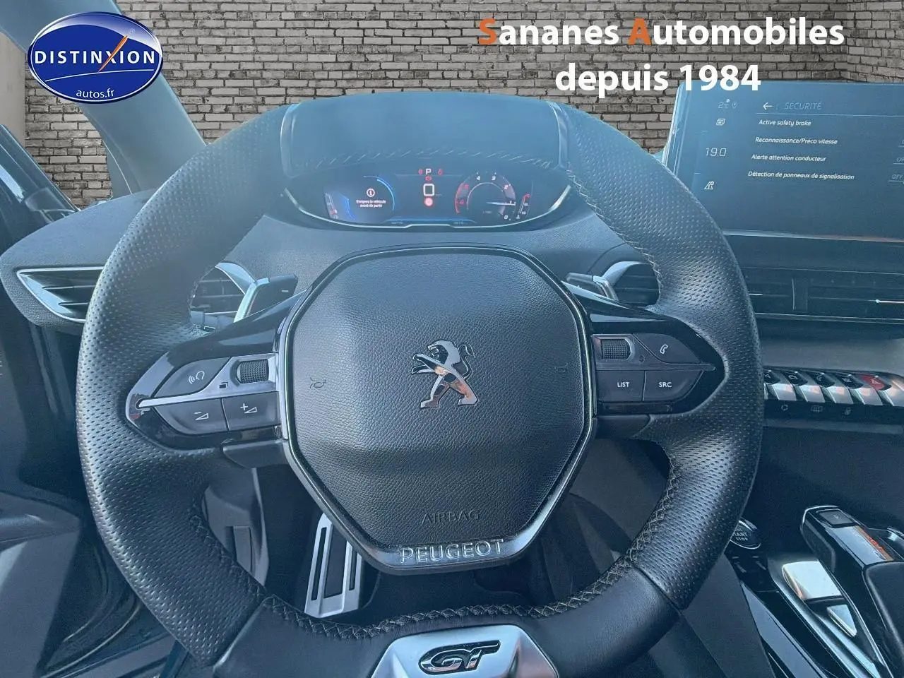 Vue rapprochée du volant cuir perforé Peugeot 3008 GT 2023 avec commandes intégrées et tableau de bord digital.