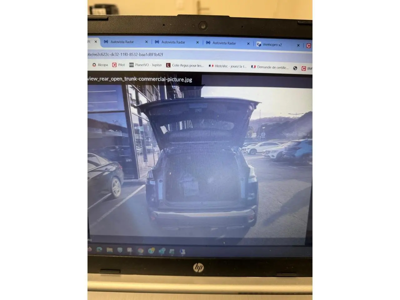 Vue arrière d'un Peugeot 3008 bleu 2023 avec coffre ouvert et intérieur de coffre visible en extérieur urbain.