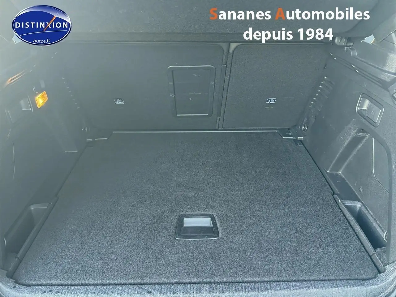 Coffre spacieux et propre du Peugeot 3008 bleu, vue intérieure arrière avec banquette rabattue et éclairage latéral allumé.
