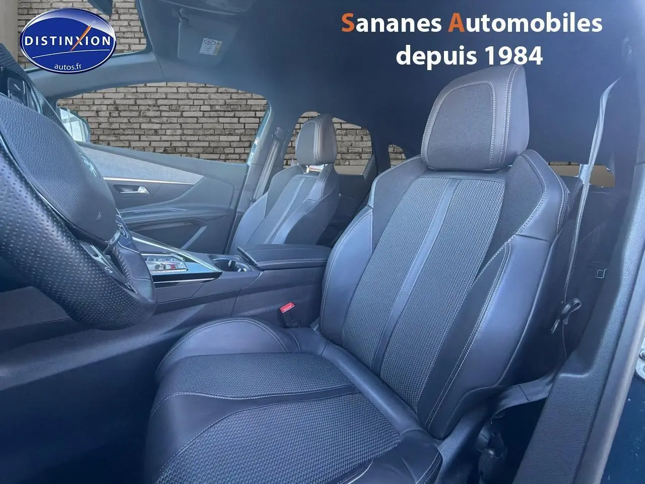 Intérieur de la Peugeot 3008 bleu, vue côté conducteur sur les sièges en cuir noir et volant perforé.