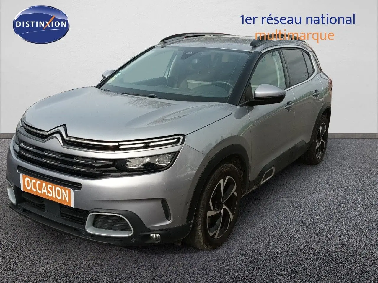 Vue 3/4 avant droit d'un Citroën C5 Aircross gris Artense métallisé avec jantes noires et toit noir.