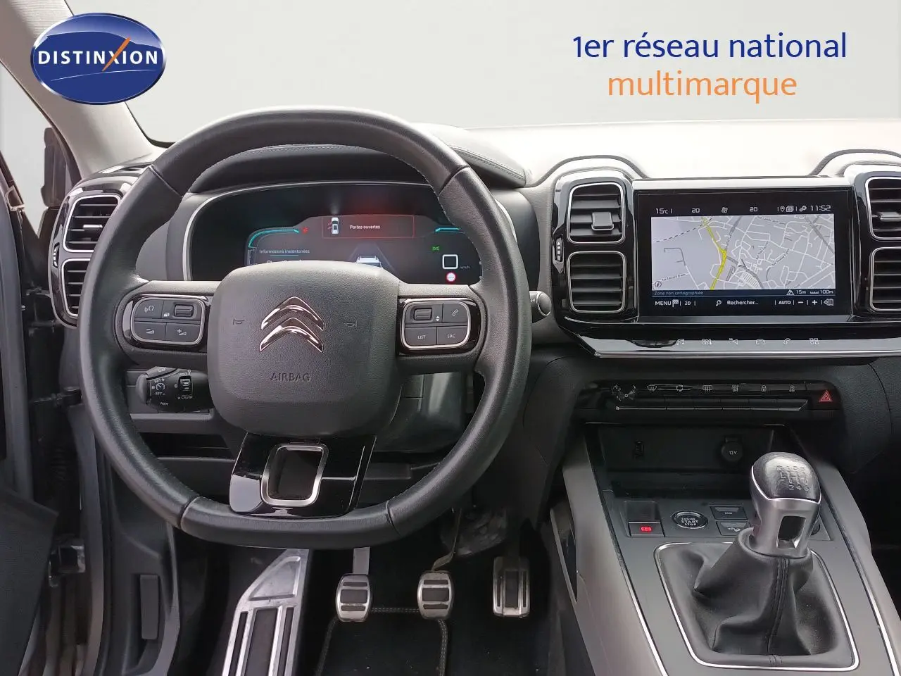 Vue intérieure centrée sur le volant et la console centrale avec levier de vitesse manuel du Citroën C5 Aircross gris 2020.