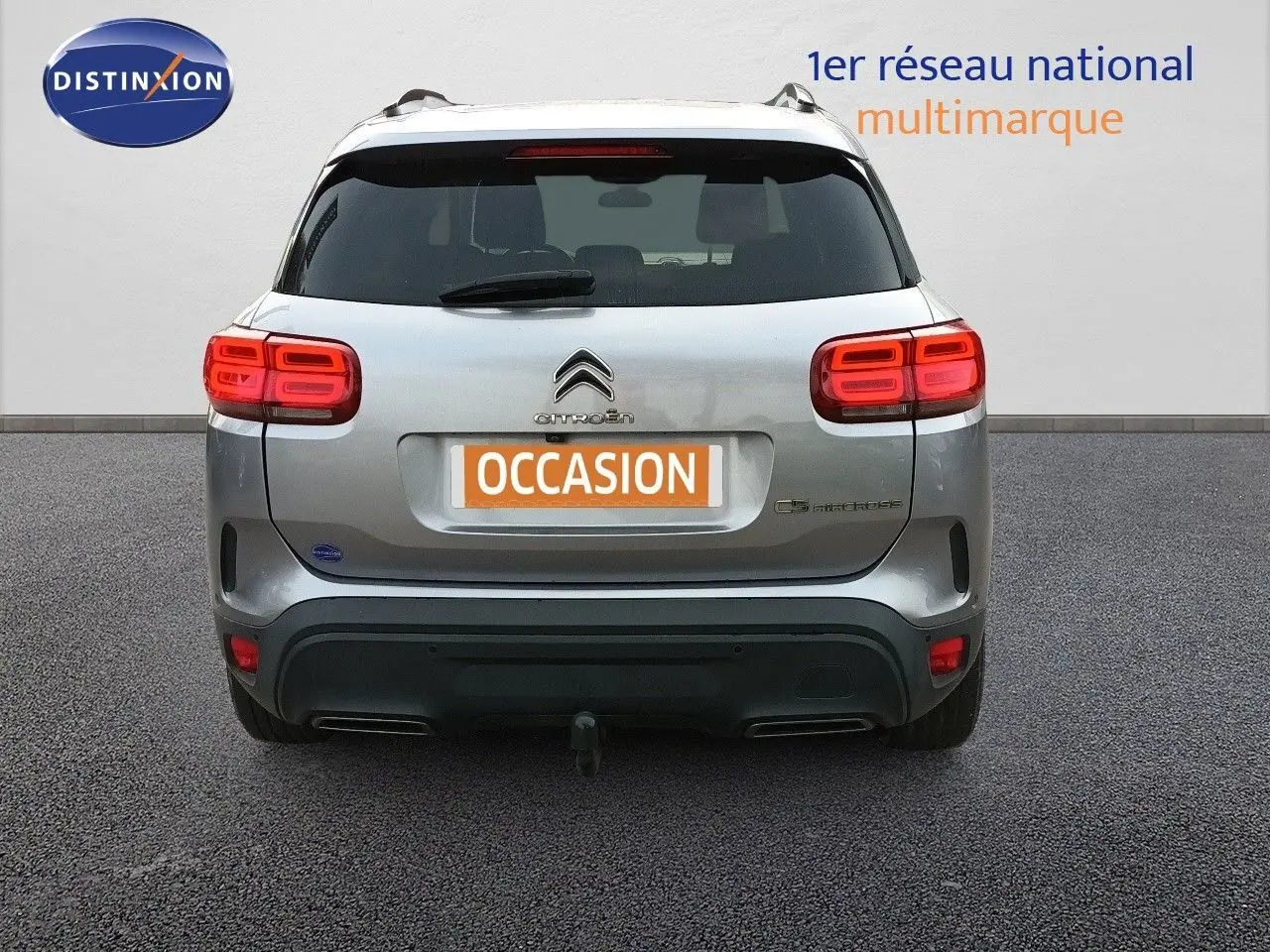 Vue arrière d'un Citroën C5 Aircross gris Artense métal avec feux LED allumés et attelage visible.