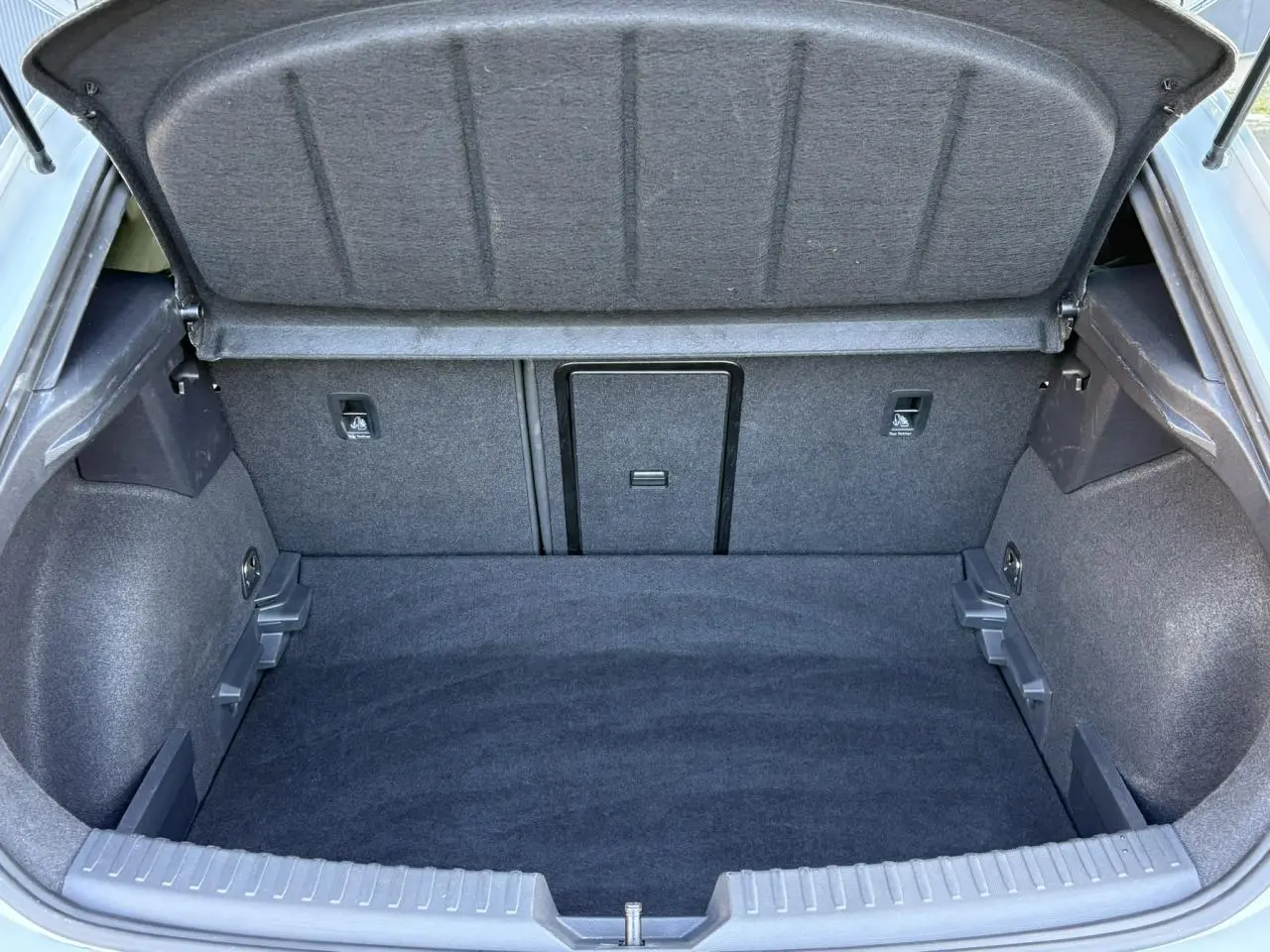 Vue intérieure du coffre ouvert de la CUPRA Leon 2025, montrant un espace de chargement propre et tapissé en tissu gris.