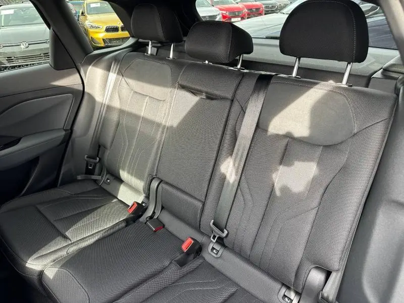 Vue intérieure sur la banquette arrière noire du SUV Audi Q3 2.0 TDI S line, avec ceintures et appuie-têtes visibles.