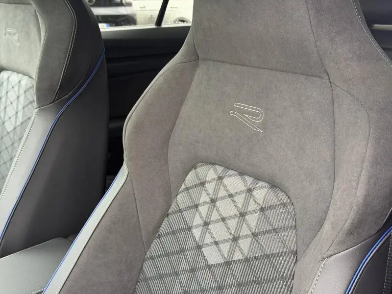 Gros plan sur le siège avant droit de la Volkswagen Golf 2.0 TDI R-Line, tissu gris avec logo R et surpiqûres bleues.