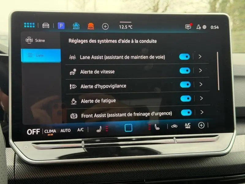 Écran tactile intérieur affichant les réglages d’aide à la conduite de la Volkswagen Golf 2.0 TDI R-Line blanc Oryx, vue de face.