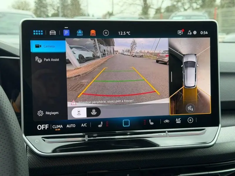 Écran tactile intérieur montrant la caméra de recul et l'assistance au stationnement de la Volkswagen Golf blanc Oryx nacré.