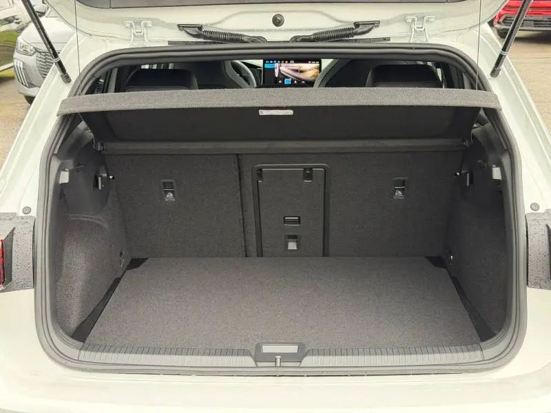 Vue arrière du coffre ouvert d'une Volkswagen Golf 2.0 TDI 150ch R-Line blanc Oryx nacré, montrant l'espace de chargement.