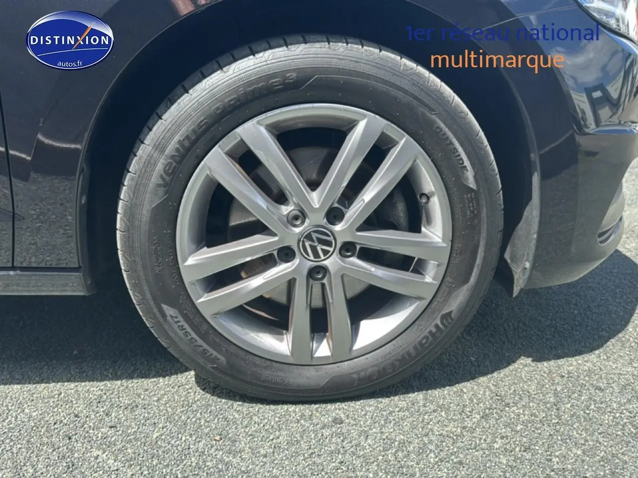 Gros plan sur la roue avant droite noire d'un Volkswagen Touran 2025 avec jante alu gris argenté.
