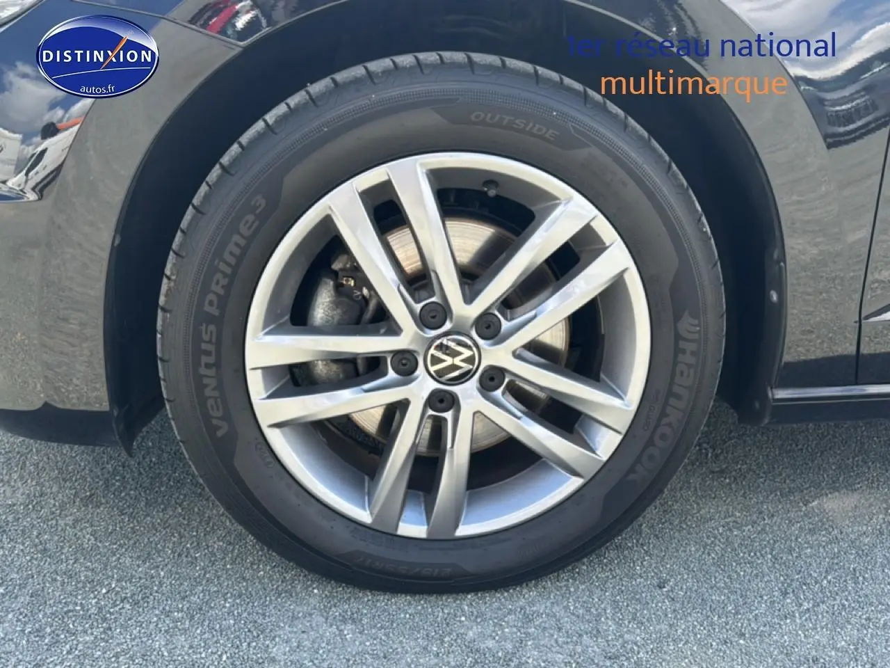 Gros plan sur la jante alu argentée et le pneu Hankook du côté gauche d’un Volkswagen Touran noir.