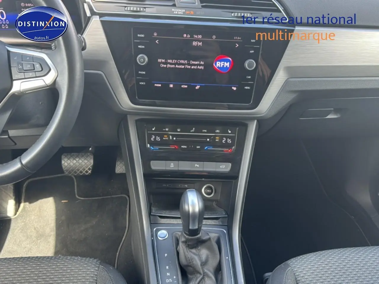 Vue intérieure avant centrée sur la console centrale et le levier de vitesse d’un Volkswagen Touran noir 2025.