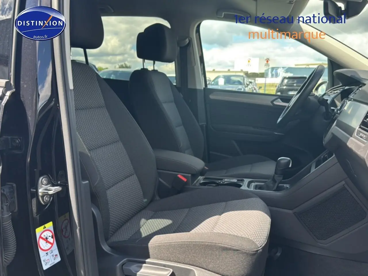 Vue intérieure côté conducteur du Volkswagen Touran noir 2025, mettant en valeur les sièges avant et le tableau de bord.