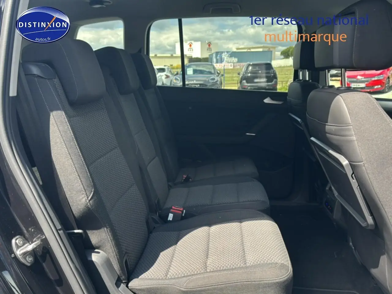 Vue latérale gauche sur la deuxième rangée de sièges noirs du Volkswagen Touran 2025 avec 7 places et intérieur spacieux.