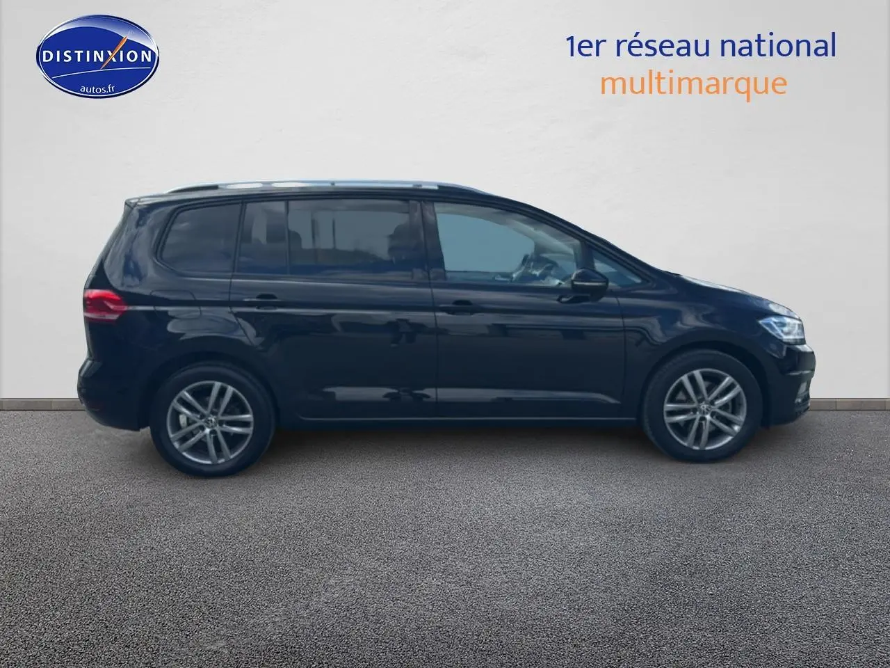 Profil latéral droit d'un Volkswagen Touran noir 2025 avec jantes alliage et vitres surteintées.