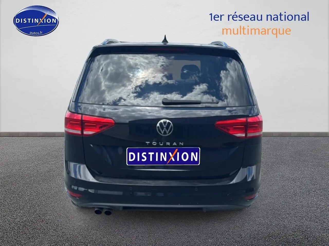 Vue arrière d’un Volkswagen Touran noir 2025 avec feux rouges et double sortie d’échappement visible.
